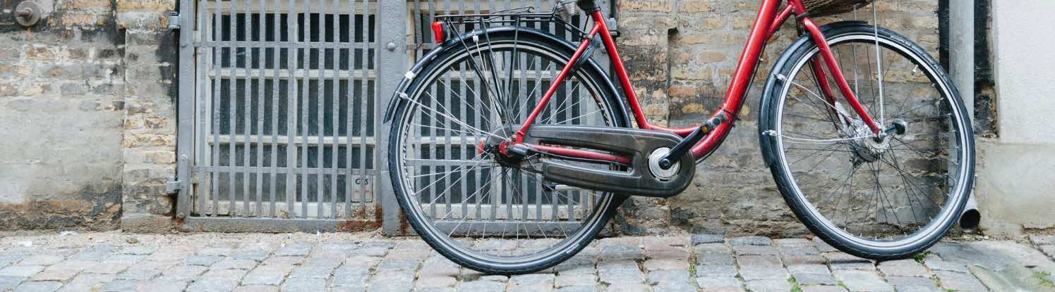 Vélo de ville rouge sur un trottoir